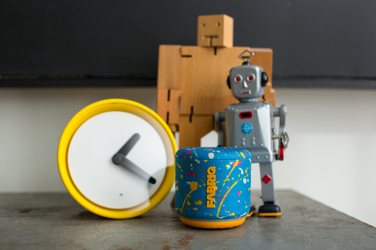 Speaker in a table with a yellow clock and robots around